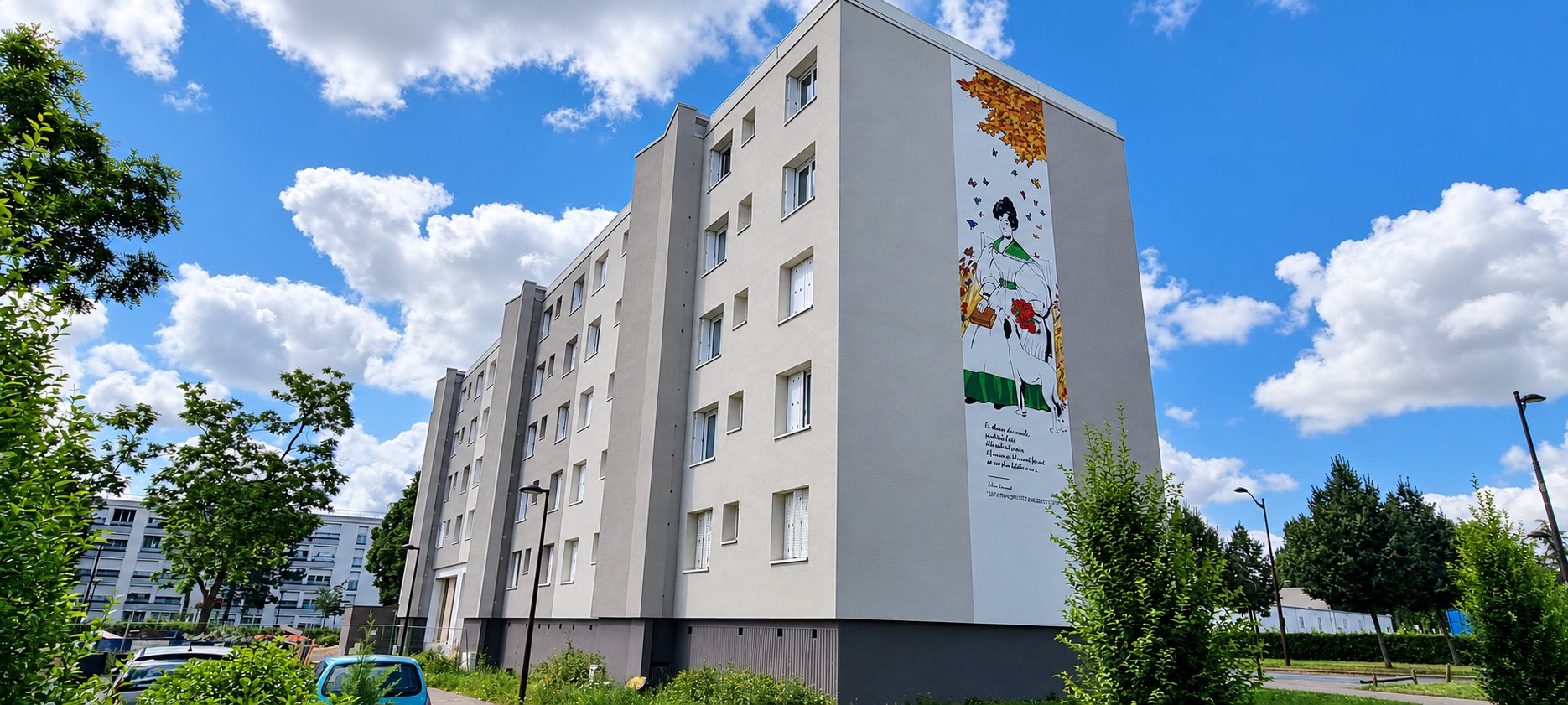 Un immeuble d'habitation de cinq étages aux façades grises fraîchement rénovées, dont le pignon porte une grande fresque représentant une femme en robe verte entourée de papillons, sous un ciel bleu nuageux.